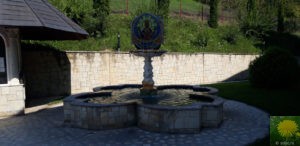 Der Brunnen im Schatten der Kirche auf dem Hügel